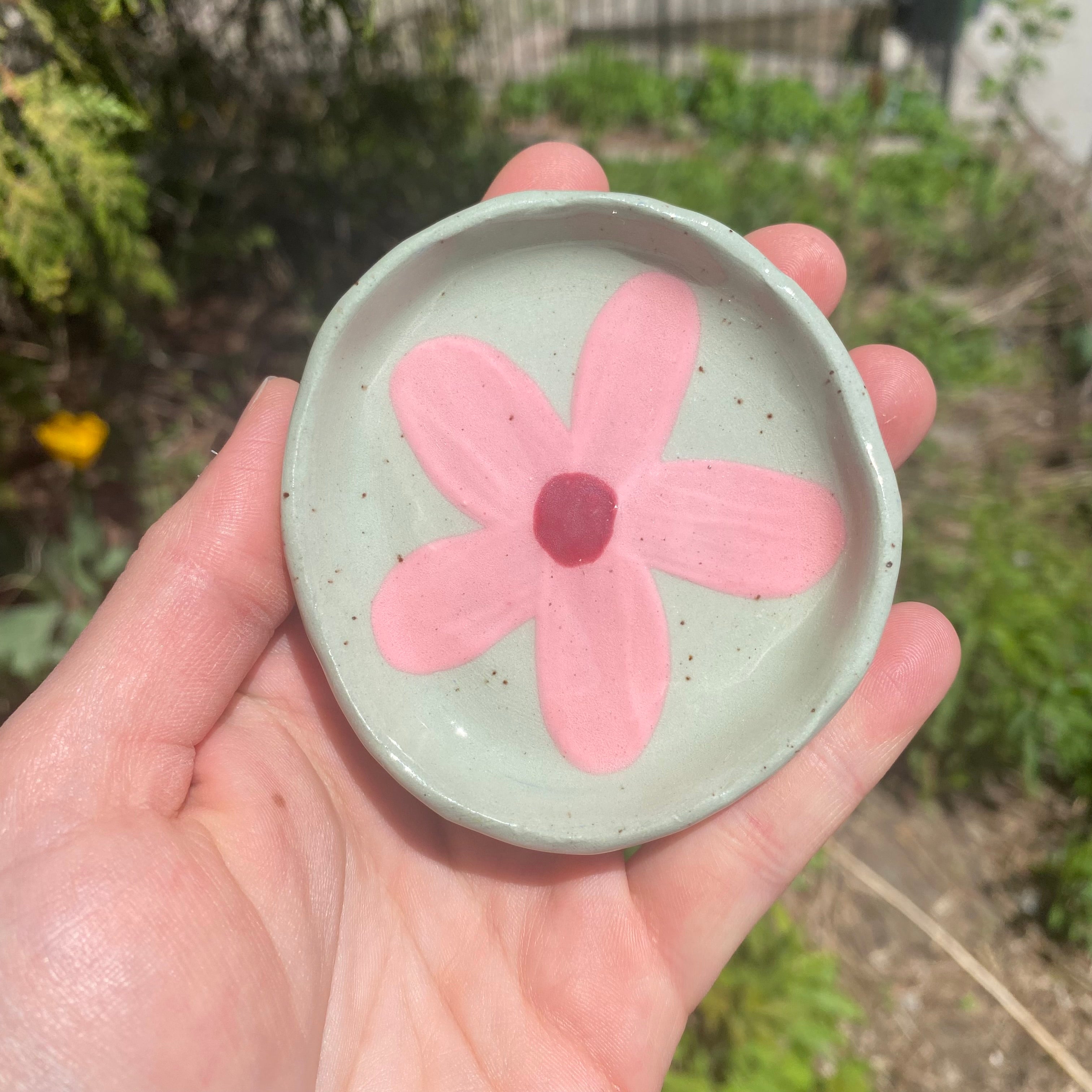 small pink floral dish on sage green clay